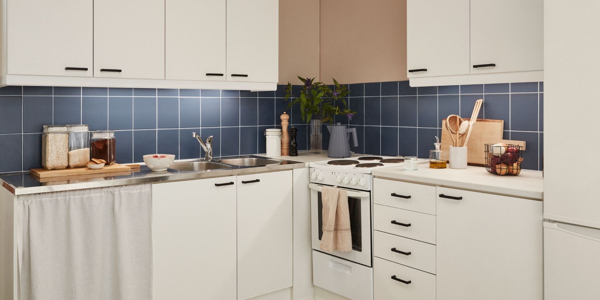 white kitchen with blue colour painted tile backsplash and muted beige wall