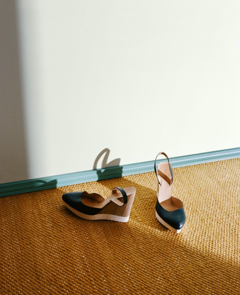 sandals on brown jute mat near soft blue-green skirting board
