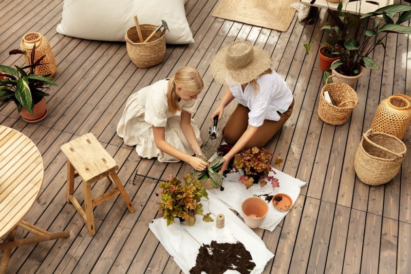mother and daughter on terrace with gardening tools and furniture