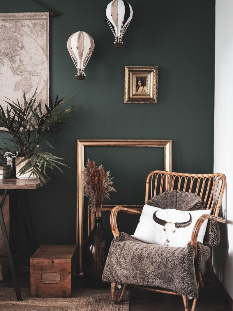 living room with dark green wall and natural material decoration
